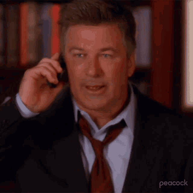 a man in a suit and tie is talking on a phone .