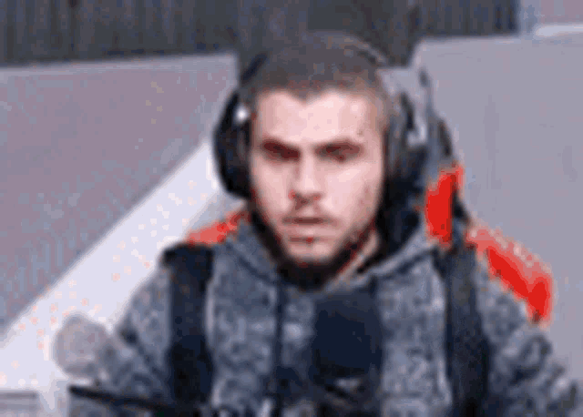a man wearing headphones and a backpack is sitting in a chair .