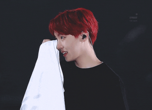 a man with red hair is smiling and holding a white towel