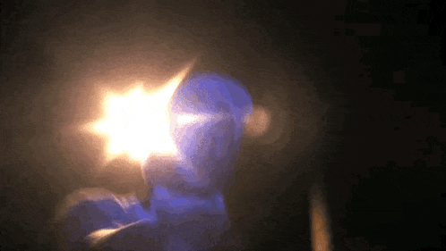 a person holding a light in front of their face in the dark