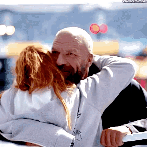 a bald man is hugging a woman with the hashtag thenextbigthing on the bottom