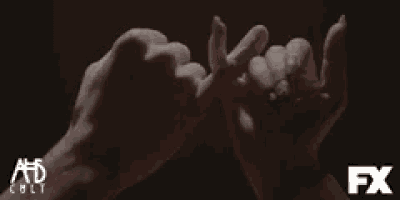 a close up of two people 's hands with a fx logo in the background