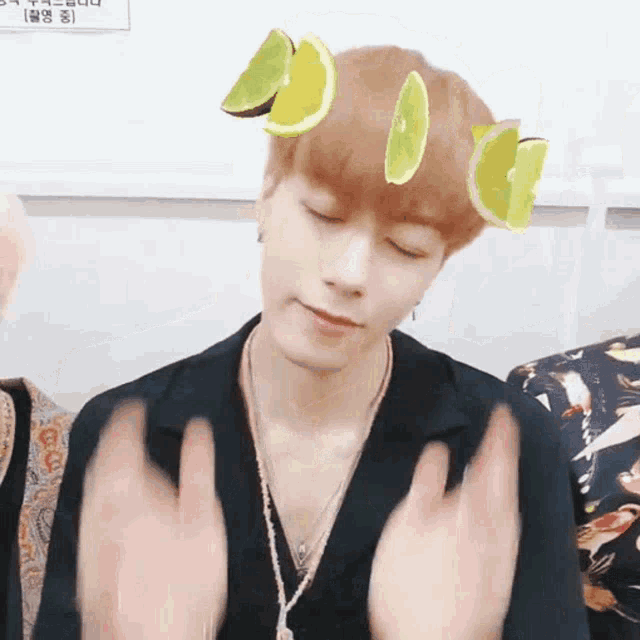 a man with slices of lemon and lime on his head