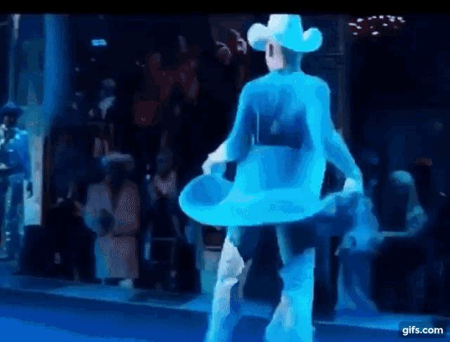 a man in a cowboy hat is dancing in front of a crowd of people .