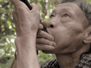 an older man is blowing a horn with his mouth