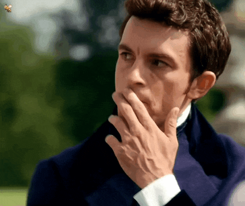 a man covering his mouth with his hand while a bee is flying in the background