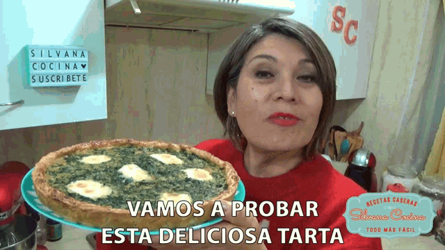 a woman is holding a pie in front of a sign that says " vamos a probar "