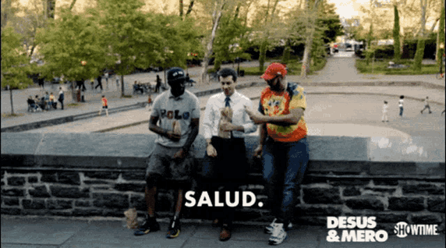 three men are sitting on a stone wall and the word salud is on the bottom left