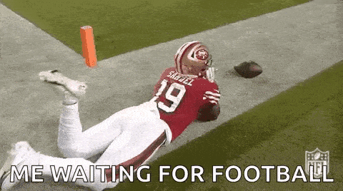 a football player is laying on the ground on a field with the words `` me waiting for football '' written below him .