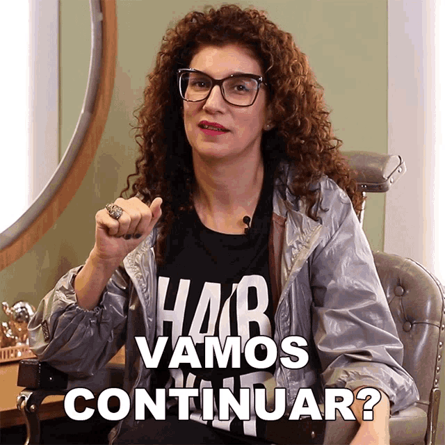 a woman with curly hair wearing a black shirt that says " hair vamos continuar "