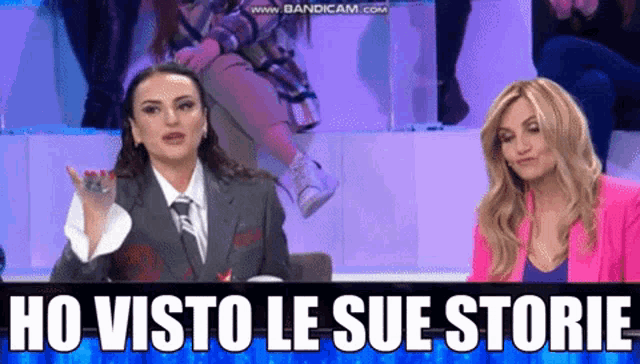 two women are sitting in front of a screen that says ho visto le sue storie on it
