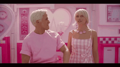 a man and a woman are standing in a pink room with a sign that says ' barbie ' on it