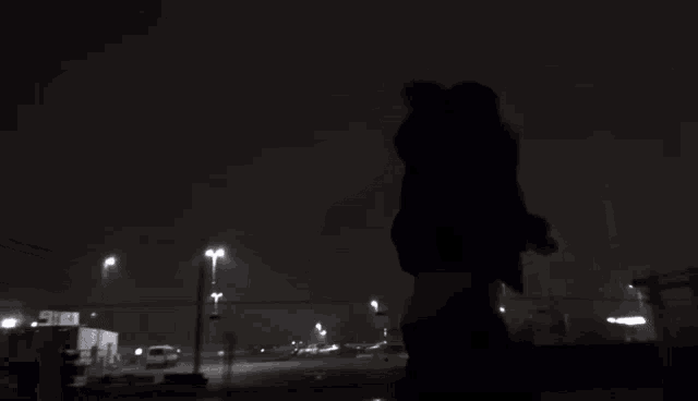 a silhouette of a person looking up at the sky