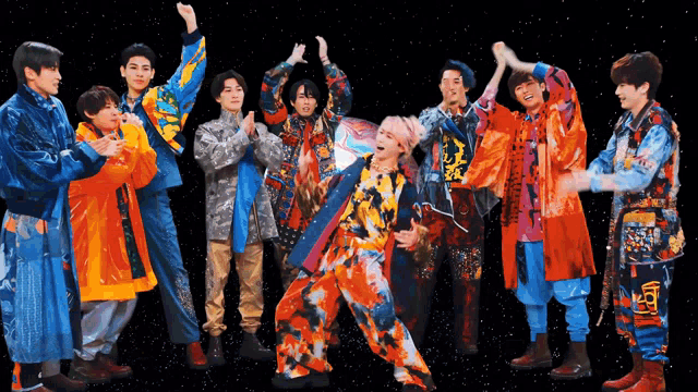 a group of young men wearing colorful clothes are standing together