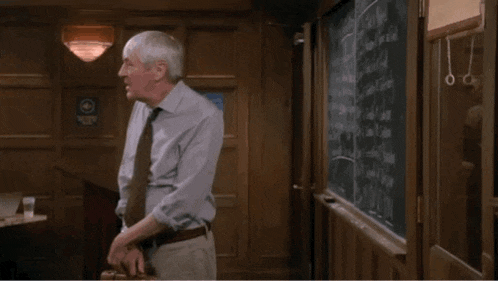 a man is standing in front of a blackboard with the number 3004 on it