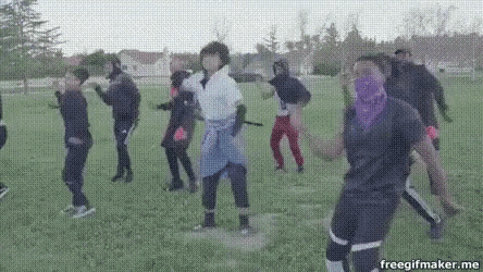 a group of people are dancing in a field with a woman wearing a purple bandana .