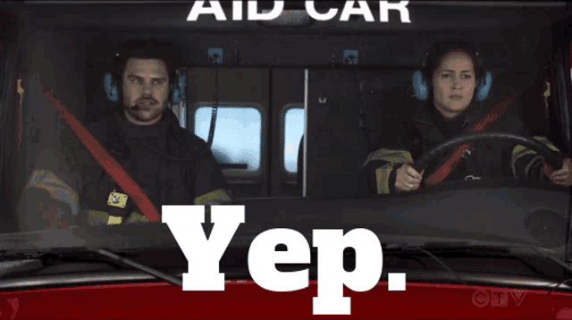 a man and a woman in a fire truck with the word yep on the bottom right