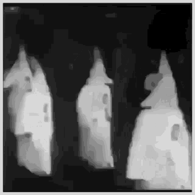 a black and white photo of three ghosts in a dark room