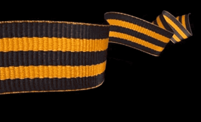 a black and yellow striped ribbon is waving on a black background
