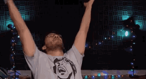 a man with his arms outstretched wearing a t-shirt with a mickey mouse face on it