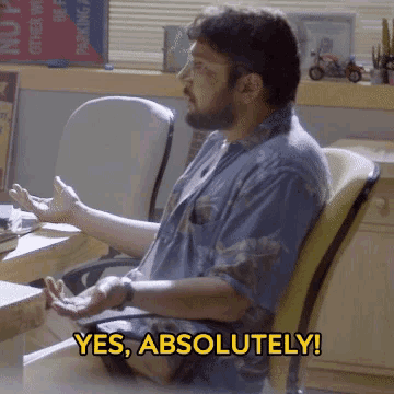 a man sitting in a chair with the words yes absolutely written on the bottom