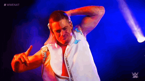 a wrestler is giving a peace sign in front of a purple background .