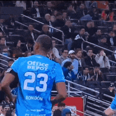 a soccer player in a blue jersey with the number 23 on it
