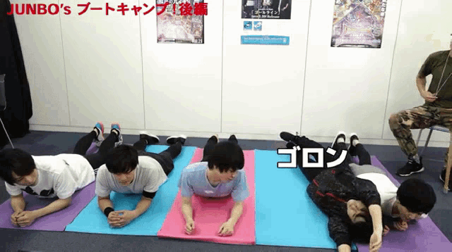 a group of young men are laying on yoga mats with jumbo 's written on the bottom
