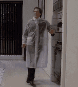 a man in a clear plastic coat is walking through a kitchen .