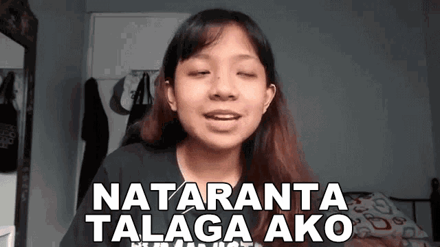 a young woman is standing in front of a mirror with her eyes closed and the words nataranta talaga ako written on her face .