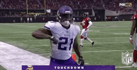 a football player wearing a purple jersey with the number 21 on it is running on a field .