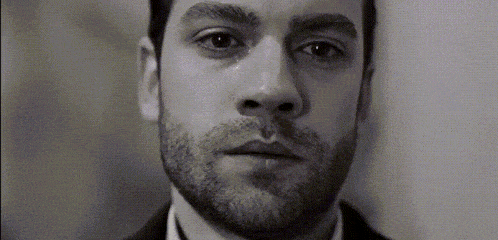 a close up of a man 's face with a tear running down his cheek