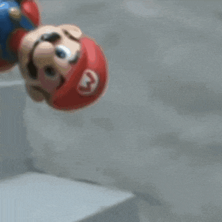 a mario figure is doing a handstand on a wall .