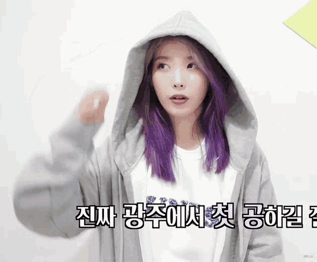 a girl with purple hair is wearing a hoodie