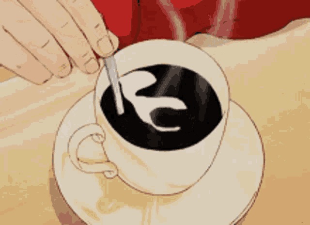 a person is stirring a cup of coffee with a k on it