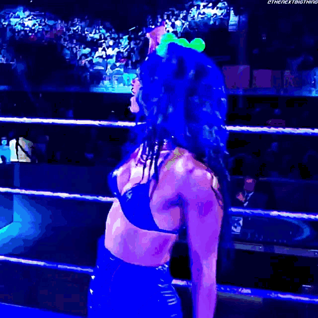 a woman with blue hair is in a wrestling ring with the next thing written on the bottom