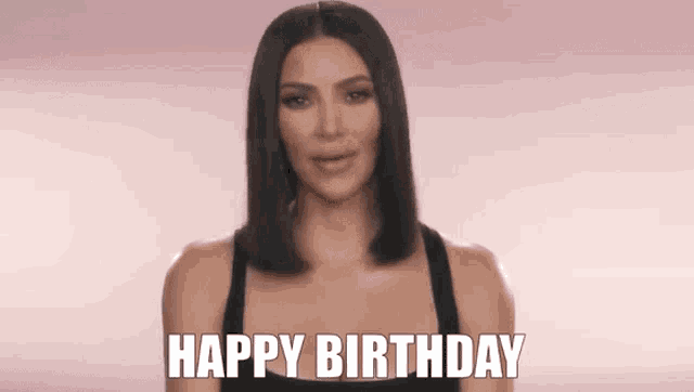 a woman in a black tank top is making a happy birthday gesture .