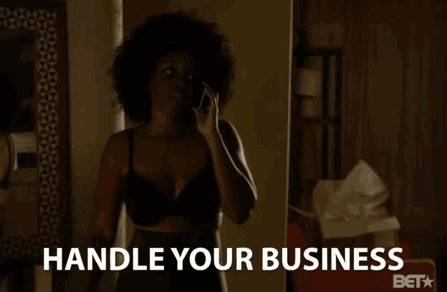 a woman in a black bra talking on a cell phone with the words handle your business behind her