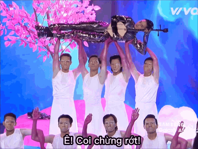 a group of men are holding up a man with a violin and a sign that says e coi chúng rồi
