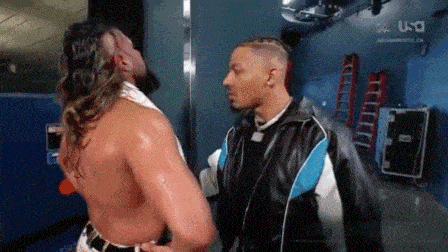 two men are standing next to each other in a locker room .