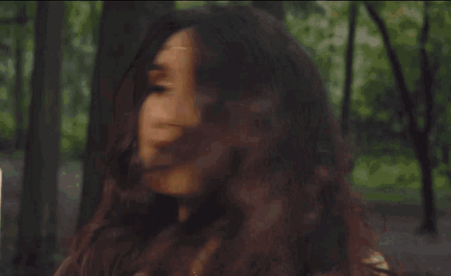 a woman with long dark hair wearing a gold headband
