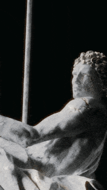 a close up of a statue of a man with a pole