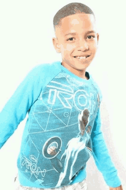 a young boy wearing a blue sweatshirt with a picture of tron on it .