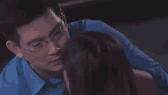 a man is touching a woman 's forehead in a close up .