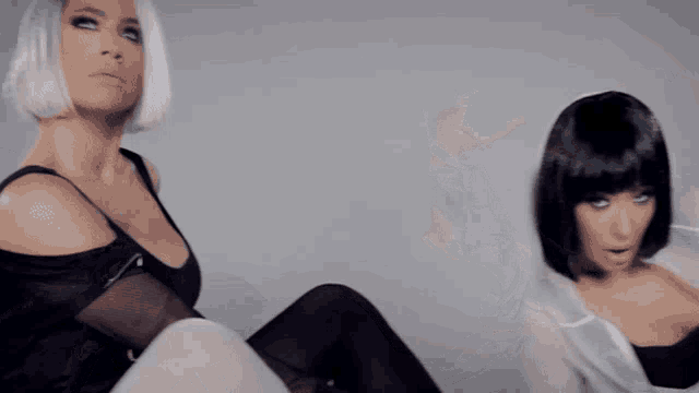 a woman in a white hoodie and black tights is doing a split