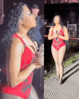 a woman in a red swimsuit is standing on a stage with a microphone .