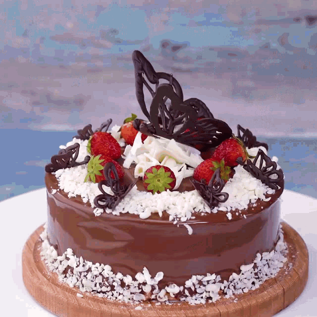 a chocolate cake with strawberries and chocolate butterflies on it