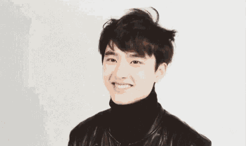 a young man wearing a black leather jacket and turtleneck is smiling .