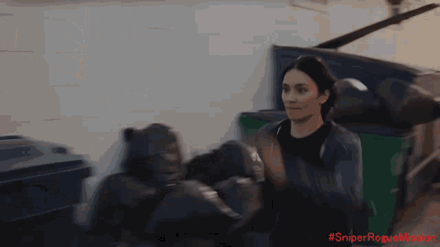 a woman in a black jacket is standing in front of a dumpster with the hashtag #sniperroguemission written on the bottom