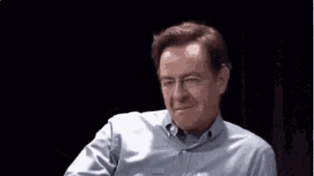 a man in a blue shirt is waving his hand .
